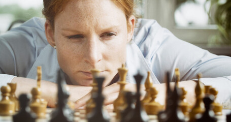 Chess player thinking about or making a move. Closeup photo, low angle.