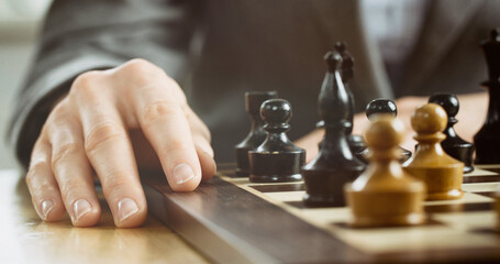 Chess player thinking about or making a move. Closeup photo, low angle.
