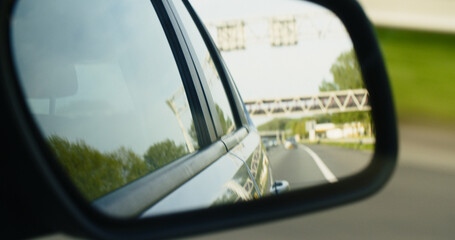 Side Rear View Mirror of a Driving Car