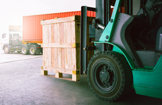 Fototapeta Forklift Tractor Unloading Wooden Crate at Warehouse. Trucks Loading Dock Warehouse. Cargo Sending to Customers. Shipment Supplies Warehouse Shipping. Freight Truck Logistic Transport.