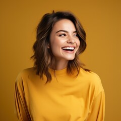 Portrait of a cheerful young woman wearing yellow shirt standing isolated over yellow background, looking at camera, posing