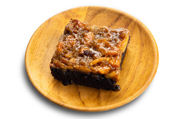 View of delicious homemade chocolate toffee cake topping with cashew nut and caramel in wooden plate.