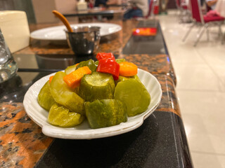 Assorted pickles vegetables carrot, chili, radish in white ceramic bowl. 