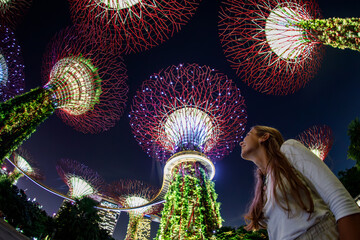 Portrait of young European woman enjoying the night light show Garden Rhapsody in Gardens by the...