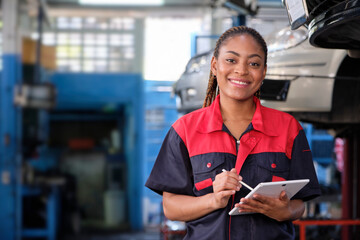 Happy Black female supervisor mechanic, cheerful smile, inspects repair work checklists with tablet...
