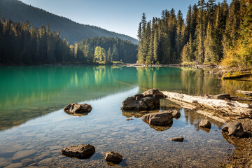 A very peaceful moment with beautiful warm sunlight at a calm Cheakamus Lake in Whistler, BC, Canada.