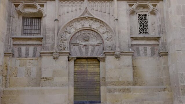 a zoom in on an exterior doorway of the mosque-cathedral of cordoba decorated in moorish architecture at cordoba, spain