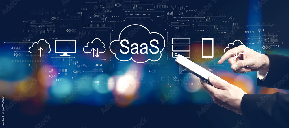 Poster saas - software as a service concept with businessman using a tablet computer at night