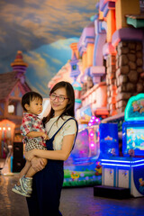 Portrait of happy mother and baby boy in amusement park night