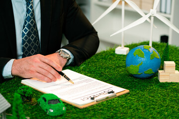 Businessman or CEO in office signing environmental regulation agreement to save Earth with...