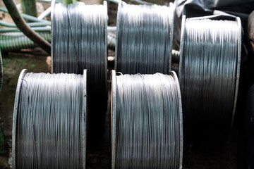 Wire production in the factory, metal wire in the coil stands on the floor in the workshop,...