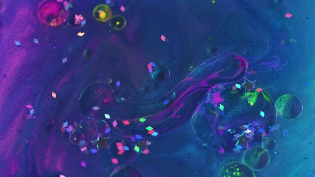 Abstract background. Paint glitter bubbles. Sparkling mix. Blue purple pink liquid ink oil spots with glowing sequins floating on shiny surface in magic art.