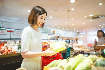 Asian woman consumer choosing organic vegetable product  at supermarket store