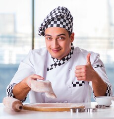 Young man cooking cookies in kitchen