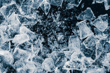 Pieces of crushed ice cubes on a black background.
