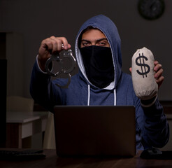 Male hacker hacking security firewall late in office