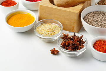 Wooden mortar with spices on white background