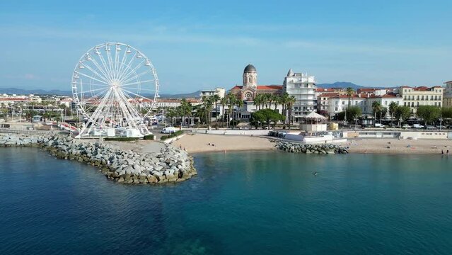 Ascending drone footage of the Ferris Wheel of Saint-Raphael and coastal old port district, France