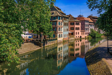 Fototapeta na wymiar Ornate traditional half timbered houses with blooming flowers along the canals in the picturesque Petite France district of Strasbourg, Alsace, France 