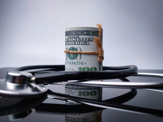 Stethoscope and banknote with reflection on a black acrylic board