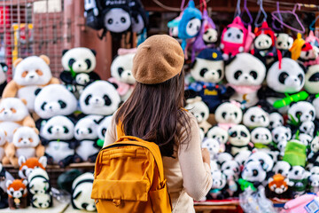Young woman traveler is shopping at a Panda souvenir shop in Chengdu, China