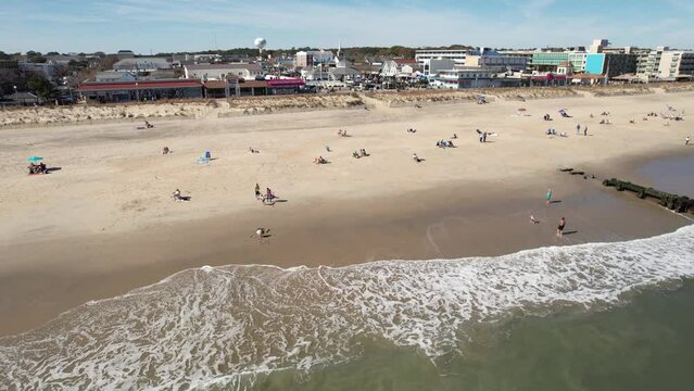 Rehoboth Beach Delaware sunny day drone flyover beach to downtown  long shot 