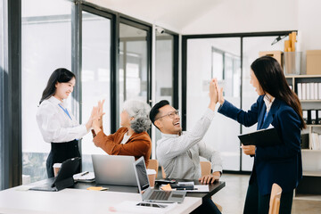 Happy businesspeople while collaborating on a new project in an office. Group of diverse businesspeople using a laptop and tablet in modern office.