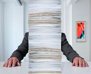 Fotobehang Angestellter hinter einem Berg Papierstabel © artfocus
