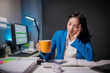 Stressed business woman working in office on laptop looking worried, tired and overwhelmed.