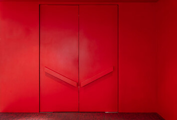 Large red door entrance to the meeting room in a red wall , Red wall texture in hall with modern...