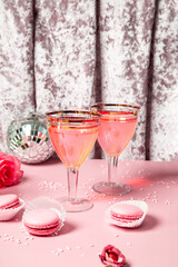 Two retro glasses with pink cocktail in a festive pink atmosphere, concept for Valentine's day