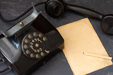 Old vintage phone and paper sheet for notes