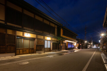 Takayama's historic old town at twilight on night sky. Traditional architecture wooden houses with light up at dusk. Beautiful town in Takayama, Gifu Prefecture, Japan.