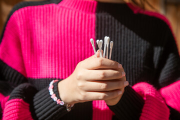Caucasian young woman holding cotton bud.