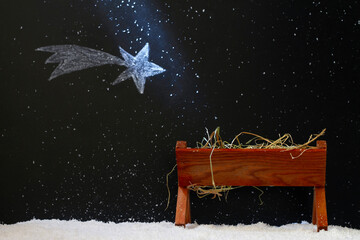 Manger and star of Bethlehem on snowy night, abstract christmas nativity scene concept