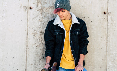 Standing young boy portrait with casual clothes trendy fashion style against a urban wall with...