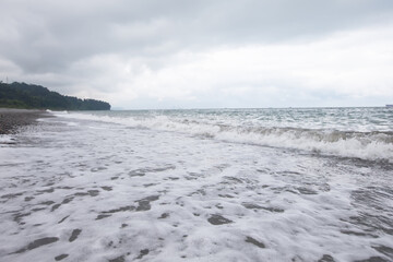 Seascape with a pebble beach and the spreading waves of the Black Sea.