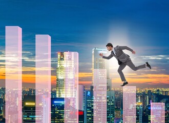 Businessman climbing bar charts in growth concept