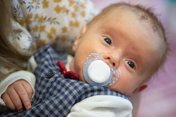 Face of a newborn baby with a pacifier.