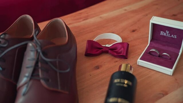 Accessories for the groom for the wedding. Shoes, perfume, bow tie and wedding rings