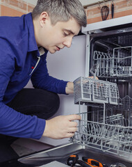 Dishwasher repair. A service center representative diagnoses and repairs a dishwashing machine at...