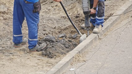 Roadworks Construction Site Conctractor Replacing Concrete Curb Brick using Shovel and Pneumatic...