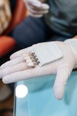 Obraz premium the dentist selects the color of the dental veneer for the patient