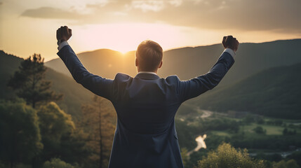 Businessman at mountaintop during sunset. Success, victory, winner, achievement, leadership concept