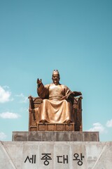 Naklejka premium a golden statue in the middle of a park that has the writing seoul on it