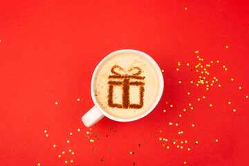 Christmas gift concept on coffee cup on red background.