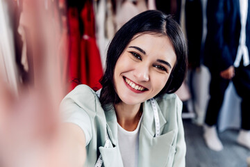 Young woman taking selfie at home. Woman in great mood takes selfie in home. Woman taking selfie photo winking to camera posing smiling playful