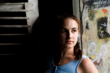 Fototapeta premium Young woman in a ruined house