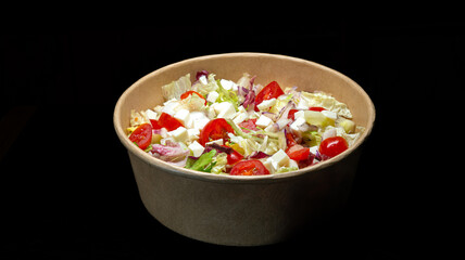 Fototapeta na wymiar vegetable salad with cheese in a bowl on black background.