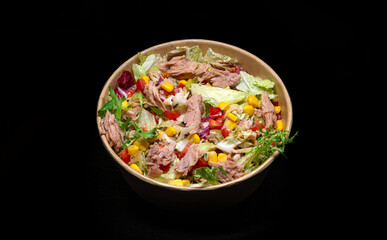 tuna salad in a bowl on black background.